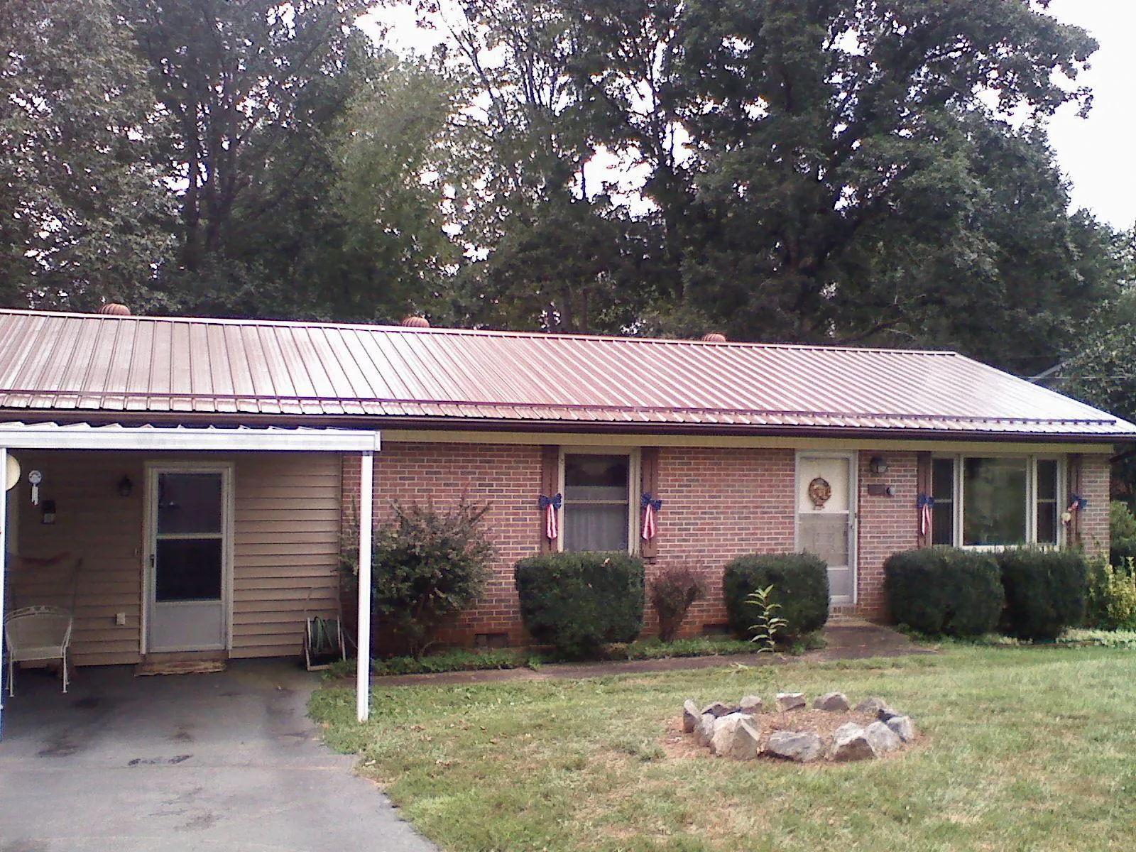 Bronze metal roof and carport on a brick ranch home — Roof Repair work by our crew in Palmer